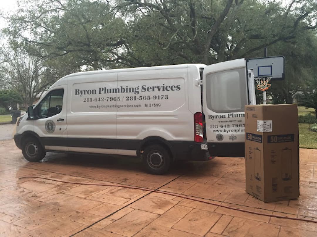 Byron Plumbing Services van parked with basketball hoop and box nearby.
