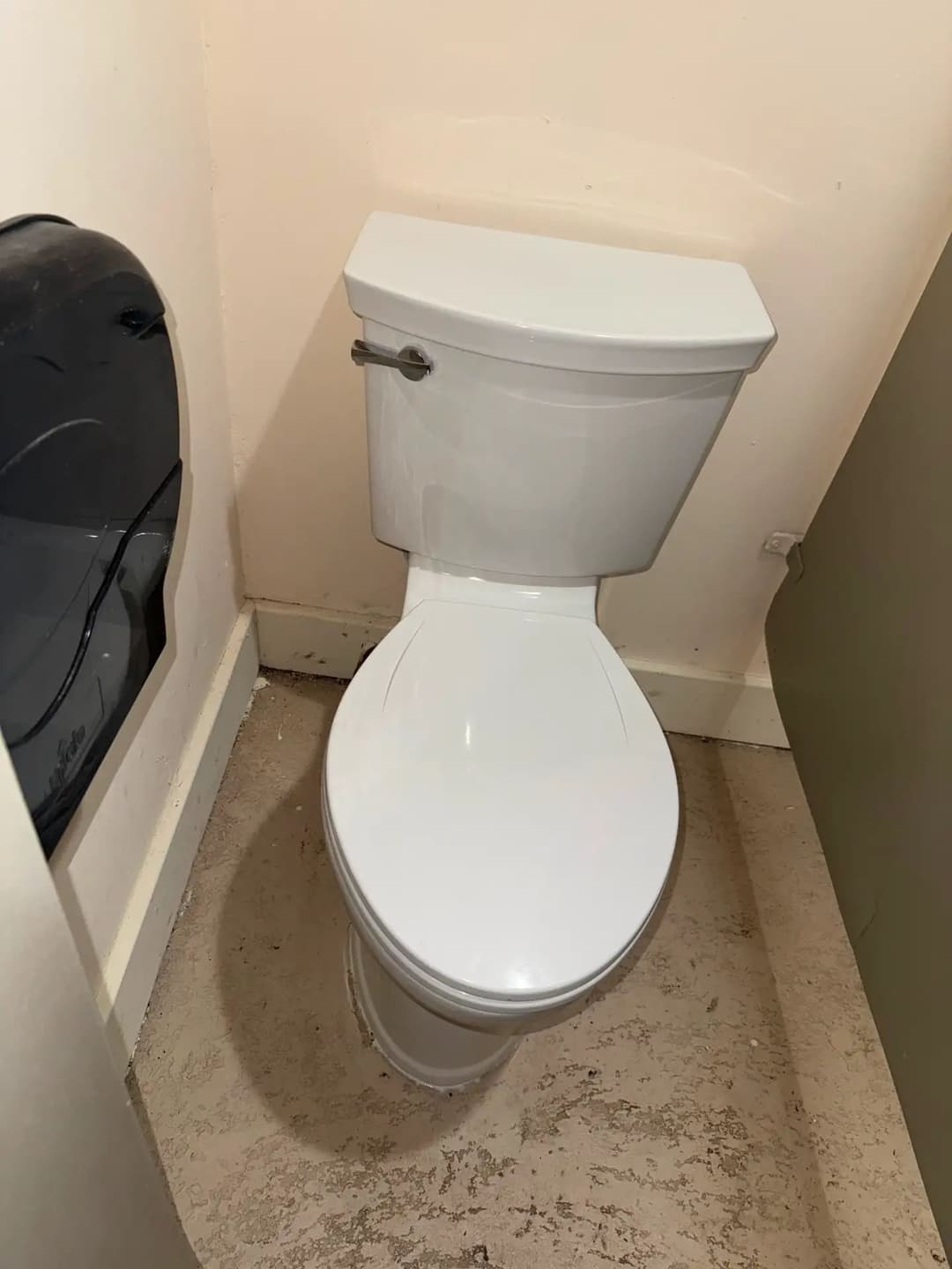 Modern white toilet in a minimalistic bathroom setting with light-colored walls.